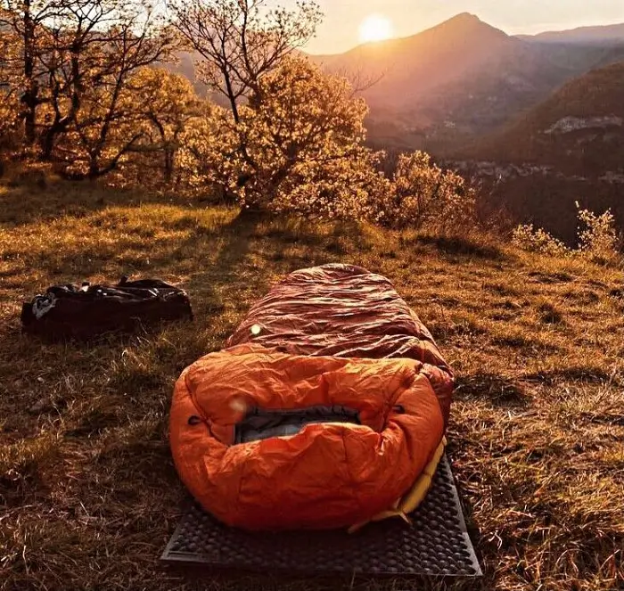 A sleeping bag laid in the middle of nature.