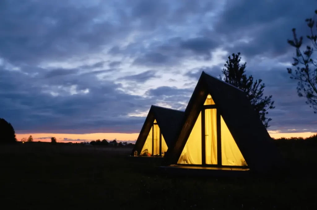 Two adjacent glamping cabins against sunset.