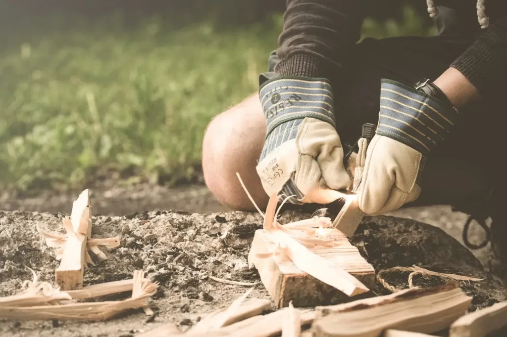 Bushcraft, a man trying to start a fire by creating sparks.