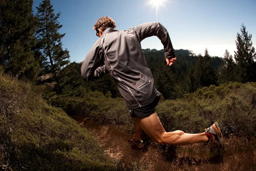 A trail running man while following a path.